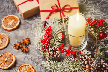 Christmas candles and ornaments over concrete background with lights.