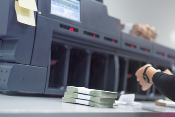 Bank employees sorting and counting money inside bank vault. Large amounts of money in the bank.