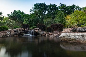 Fototapeta na wymiar Pond reflection with waterfall