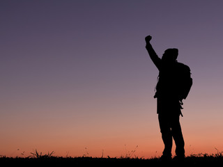 Fototapeta na wymiar Silhouette of travel man with backpack raised hands on the mountain. success concept.