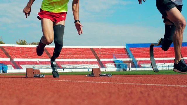Two runners with artificial legs are practicing