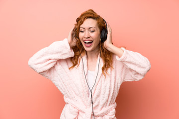 Redhead woman in dressing gown listening music