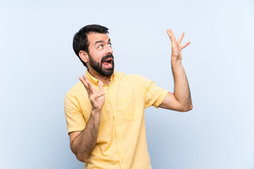 Fototapeta premium Young man with beard over isolated blue background nervous and scared