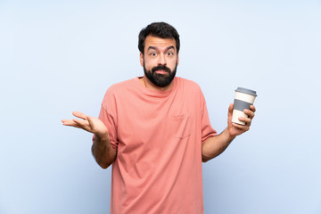 Young man with beard holding a take away coffee over isolated blue background making doubts gesture