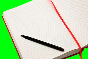 Red notebook on a green background