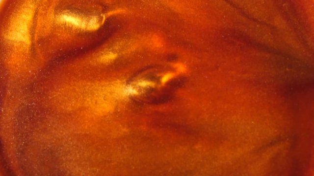 red-orange liquid with sparkles and pearly shine. abstract background. Slow motion