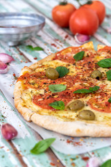 Freshly made wood fired pizza viewed from above on rustic turquoise boards