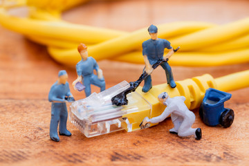 Close up miniature technician teamwork maintenance rj45 with network cable. telecommunication concept.