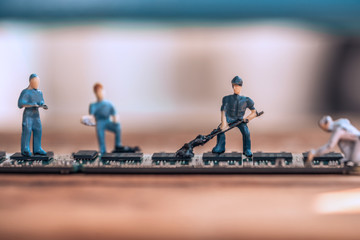 Close up miniature technician teamwork maintenance digital circuit memory.