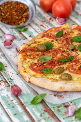 Freshly made wood fired pizza viewed from above on rustic turquoise boards