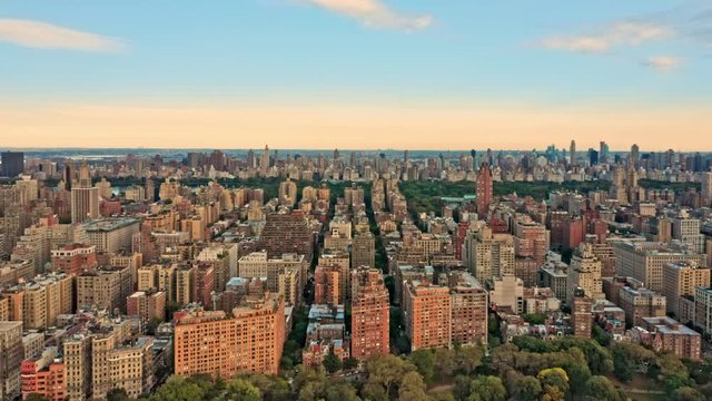 Aerial drone footage of New York midtown skyline at sunset viewed from above upper West Side neighborhood, with slow camera rotation