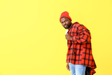 Portrait of handsome African-American man on color background