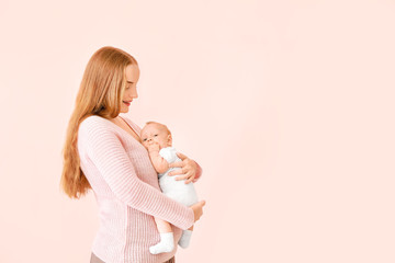 Mother with cute baby on color background