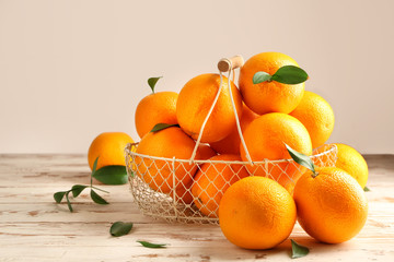 Basket with fresh oranges on white table