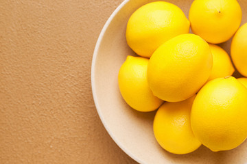 Plate with ripe lemons on color background, closeup