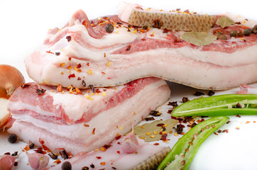 Pork belly fresh meat with spices preparation for salting on a white background