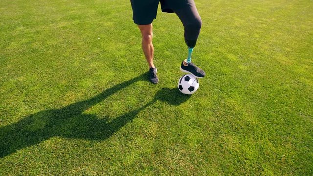 A man with a bionic leg is kicking the ball around