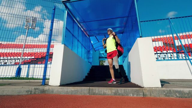 Disabled man with an artificial leg is coming into the stadium