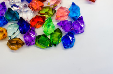 Multi-colored plastic stones on a white background. Hand made background