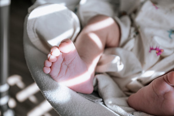 Cute baby small feet with morning sunlight