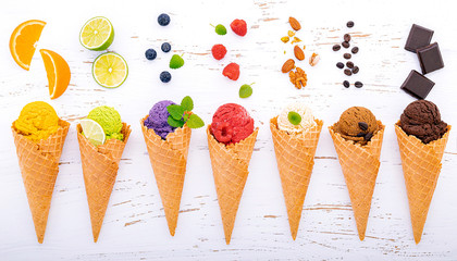 Various of ice cream flavor in cones blueberry ,lime ,pistachio ,almond ,orange ,chocolate ,vanila and coffee setup on shappy wooden background . Summer and Sweet menu concept..