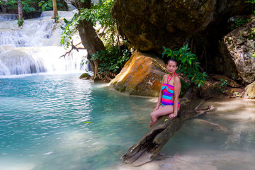 Woman in bikini beautiful happy with waterfall