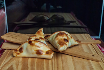 Sfiha, kind of pie like originating in Syria and Lebanon and widely consumed in all the world, on rustic wooden table.