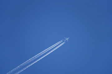Airplane in the sky leaving a vapor trail