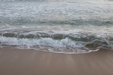 Sandy beach and soft wave of the sea