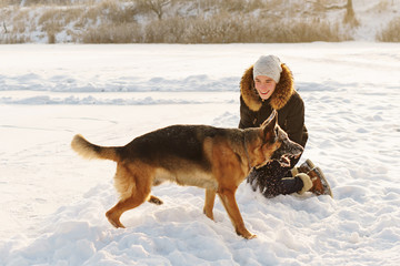 Stylish guy walk the dog. Having fun playing in snow outdoors. Playful mood. Animal lover. German Shepherd enjoying freedom. Friends together. Funny expressive leisure time. Cynologist