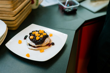 pancakes with blueberry and peach on white dish