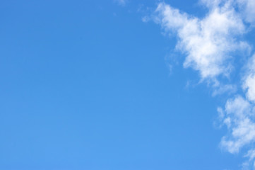 The blue sky, with pure white clouds floating on the air a little. Bright atmosphere, beautiful sky. With free space in the air. When looking at the sky, the blue felt strong.