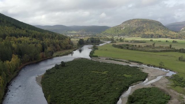 Aerial view of the River Dee near the Scottish town of Ballater in the Cairngorms National Park, Aberdeenshire. Flying forward over fields and the river.