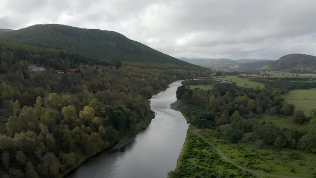 Aerial view of the River Dee near the Scottish town of Ballater in the Cairngorms National Park, Aberdeenshire. Flying forward over fields and the river.