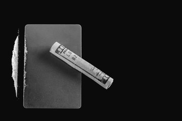 Drugs. Cocaine, plastic card and one hundred dollar bill on a black background. Black and white image.