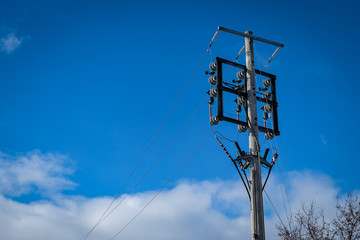 An electric transformer pole with a beautiful sky background.