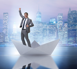 Obraz premium Excited businessman riding paper ship boat