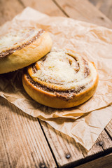 Fresh cinnamon buns on the rustic wooden background. Selective focus. Shallow depth of field.