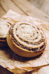 Fresh cinnamon buns on the rustic wooden background. Selective focus. Shallow depth of field.
