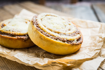 Fresh cinnamon buns on the rustic wooden background. Selective focus. Shallow depth of field.