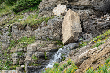 Large boulder blocking part of the waterfall in Glacier national park, Montana.
