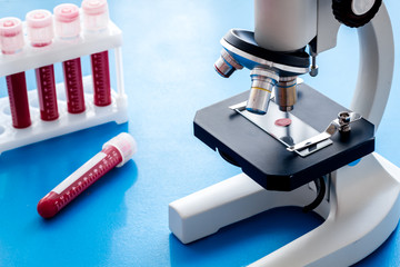 Blood testing. Samples viewing undermicroscope on blue background top view