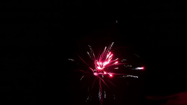 Red firework element on black background night to create video about salute on holiday and pyrotechnics happy New Year, Christmas, birthday greetings.