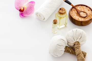 Massage thai herbal balls near spa accessories and orchids on white background copy space