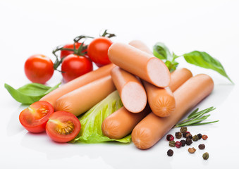 Classic boiled meat pork sausages with pepper and basil and cherry tomatoes on white background.