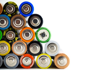 A large number of old AA batteries in different colors. Batteries on white background