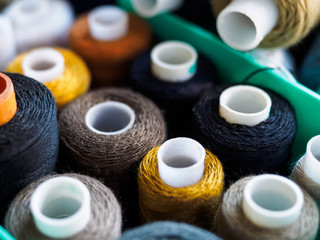 Reels with threads of different colors for sewing. Threads located in the box. The view from the top on threads for sewing.