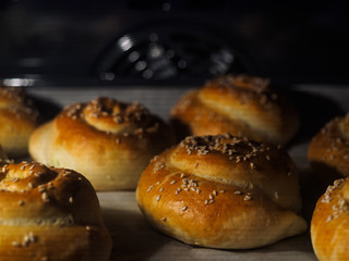 Buns sprinkled with sesame seeds are cooked in the oven