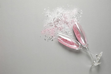 Flat lay composition with champagne glasses for celebration on grey background. Space for text