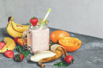 banana, strawberry and orange smoothies with mint on the table, front view